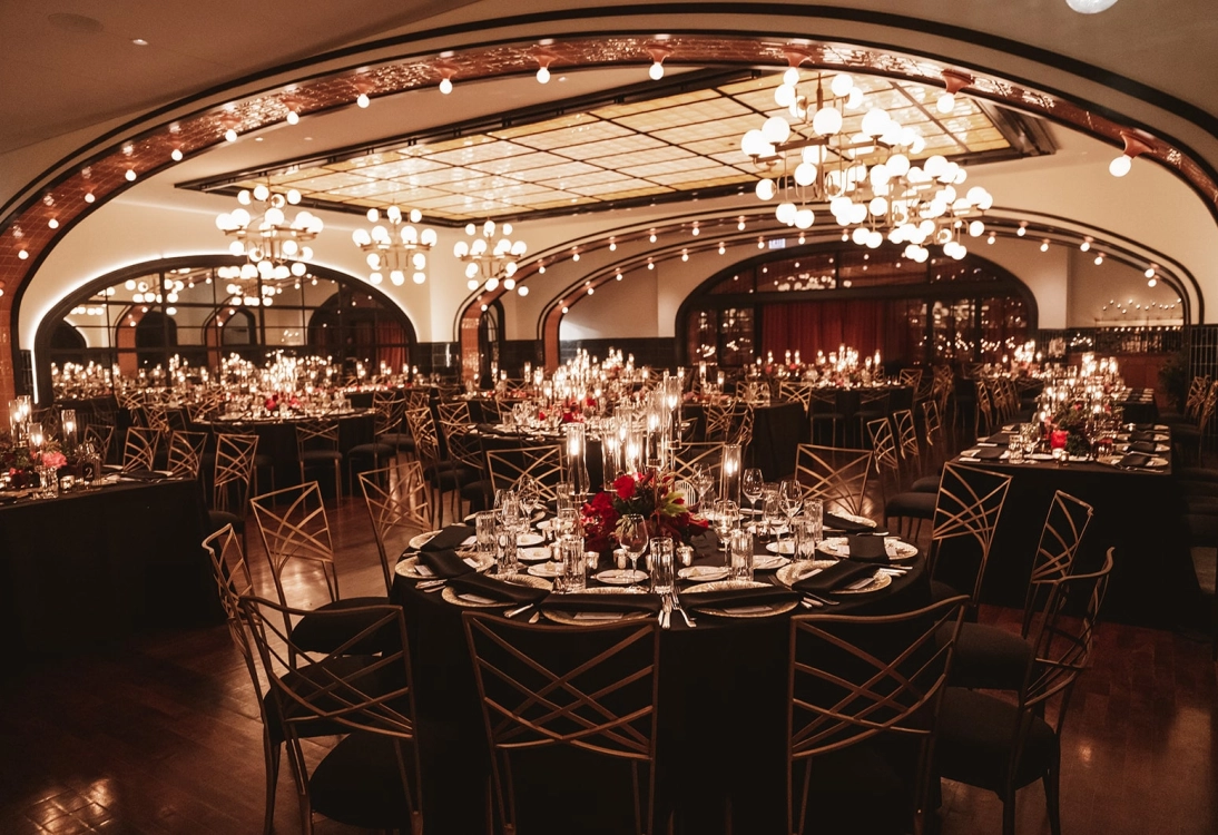 Elegant dining room setup with multiple tables, candles, and ambient lighting, creating a luxurious atmosphere.