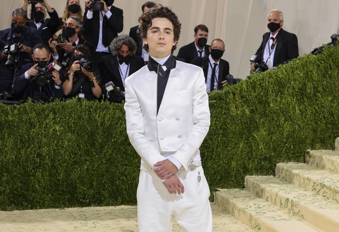 Met Gala co-host Timothée Chalamet brought casual elegance to the red carpet in a Haider Ackermann suit and high-top, white Converse.