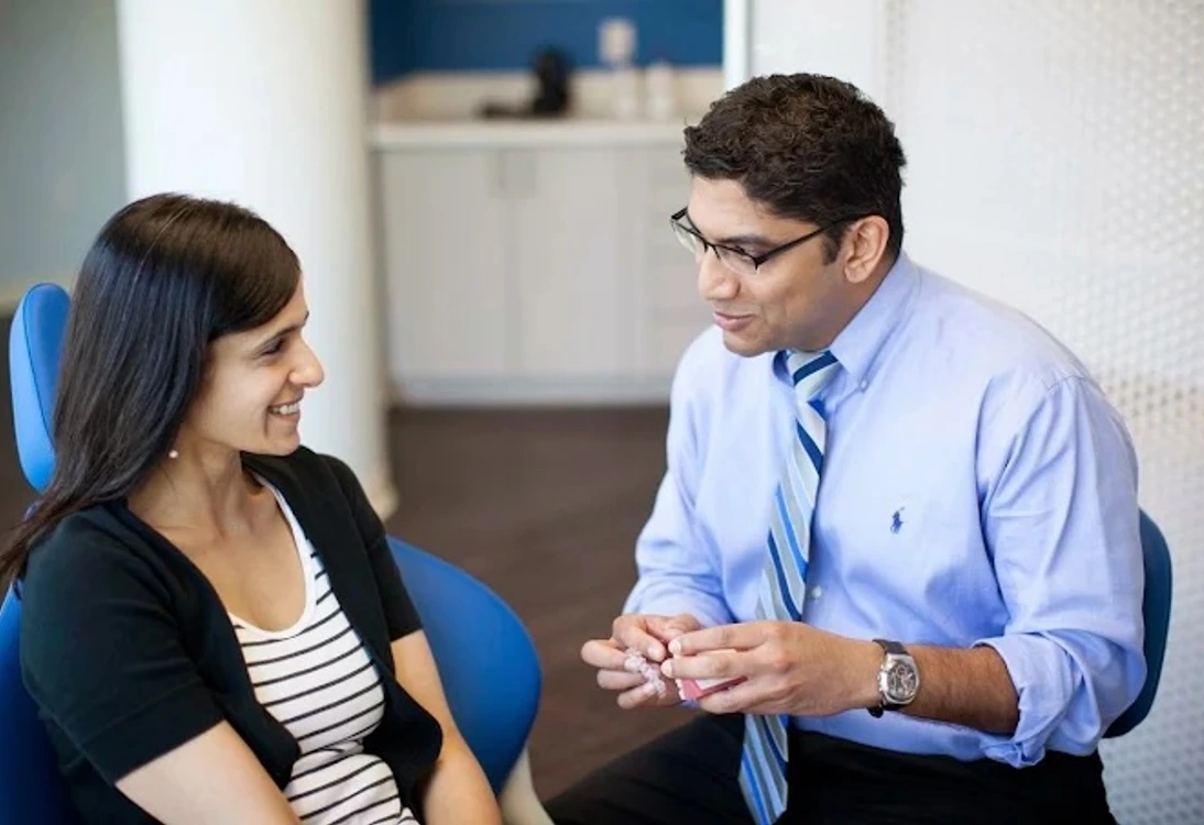 Two people sitting and engaging in a friendly conversation in an office setting.