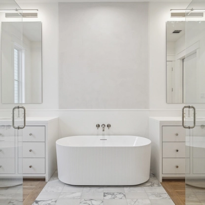 Modern bathroom featuring a freestanding tub, double sinks, and large mirrors. Bright and contemporary design.