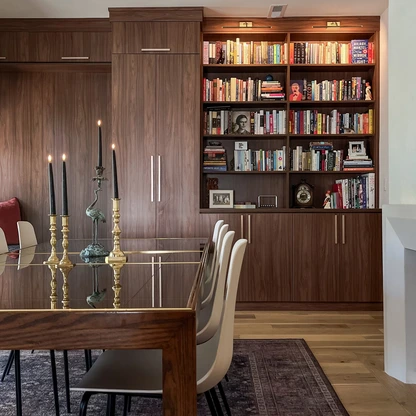 Bookshelf filled with books and some decorative items beneath ceiling lights in a modern room.