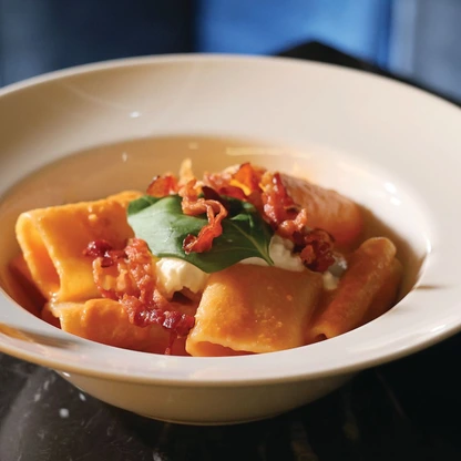 The paccheri ai tre pomodori features a delicate, flavorful tomato sauce topped with crispy bacon and creamy burrata PHOTO BY ARMANI THAO