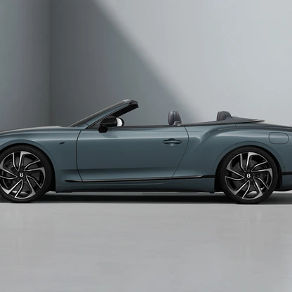 Side view of a sleek blue convertible sports car with black rims in a minimalistic studio.