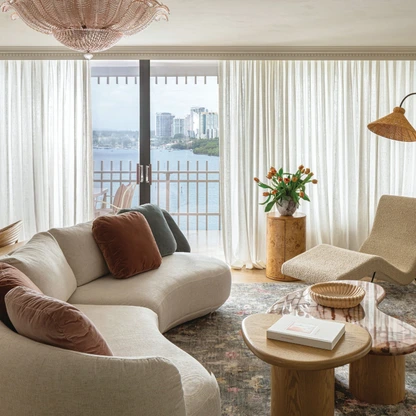 A pink Murano glass chandelier from 1stdibs splashes soft color and vintage glam to the living room, filled with shapely furnishings like the Nicoline sofa from Addison House and the chaise from Design Within Reach. The custom cocktail tables are by Casa Oh.