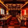 Elegant restaurant interior featuring a long dining table with warm lighting and modern decor.
