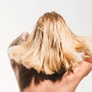 Blonde woman hair in motion from the back, fashion portrait with dynamic energy