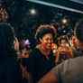 Group of people socializing and smiling at an outdoor evening gathering.