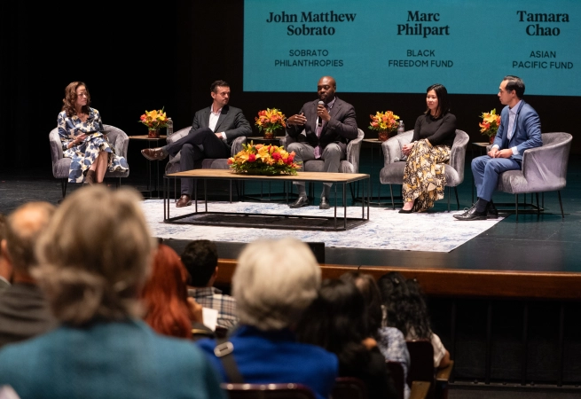 Panel discussion featuring John Matthew Sobrato, Marc Philpart, Tamara Chao, and a female moderator, with an audience present.