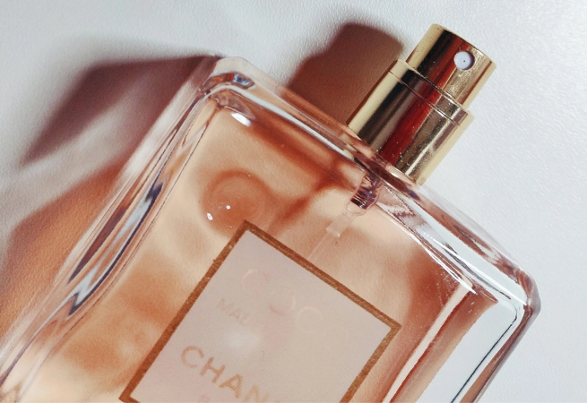 Close-up of a Chanel Coco Mademoiselle perfume bottle with a gold spray nozzle.