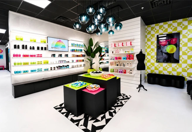 Bright, modern retail store interior with colorful products, geometric decor, black mannequins, and contemporary lighting fixtures.