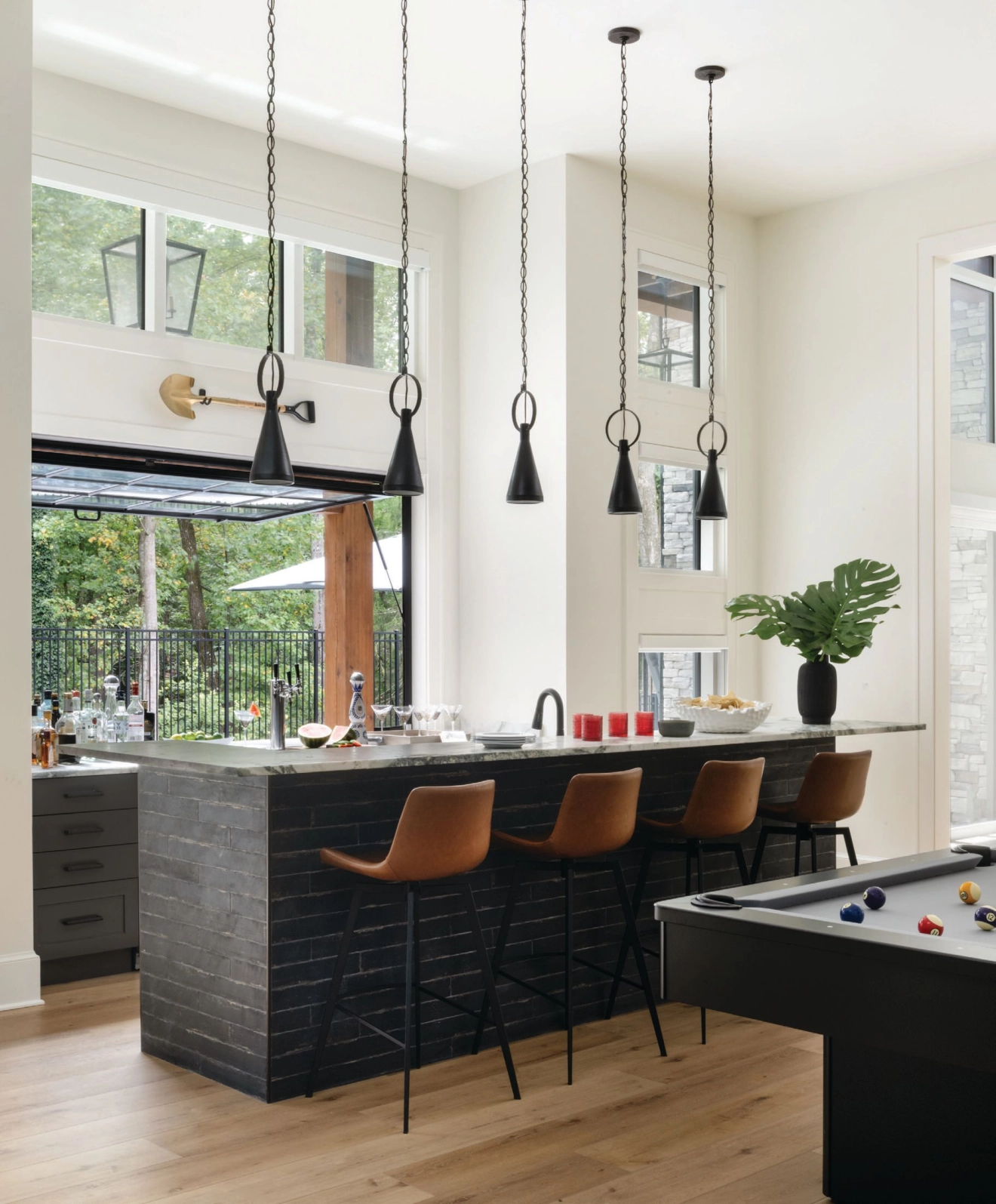 The home's lower level includes a game room and bar that opens to the backyard deck. photographed by ROBERT RADIFERA styled by CHARLOTTE SAFAVI