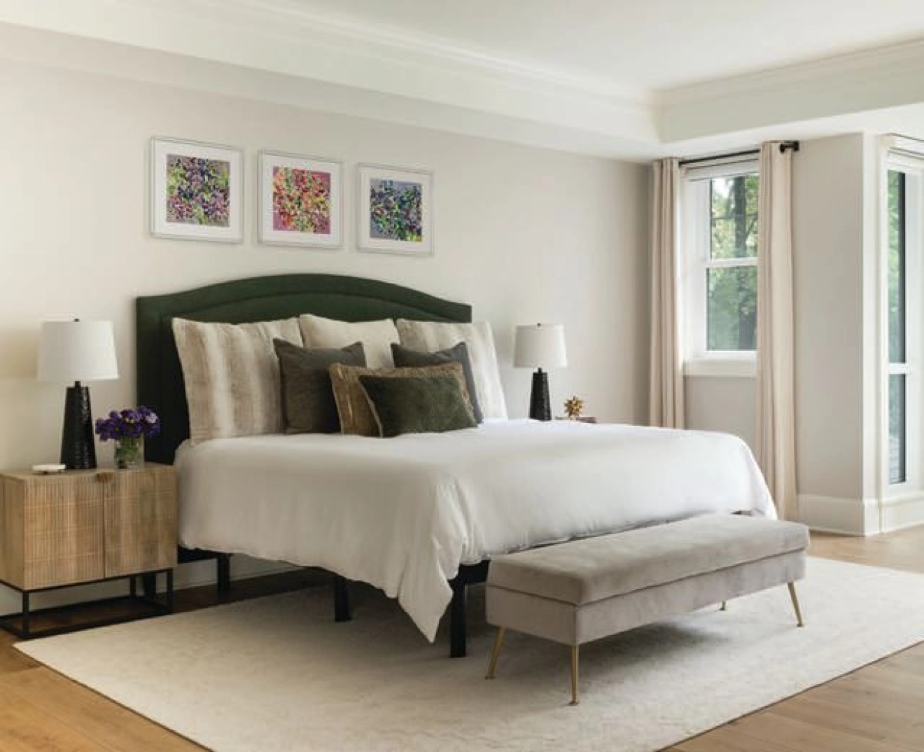 The primary suite, complete with a bed and bench from West Elm, feels like it's part of the forest canopy outside the window photographed by ROBERT RADIFERA styled by CHARLOTTE SAFAVI