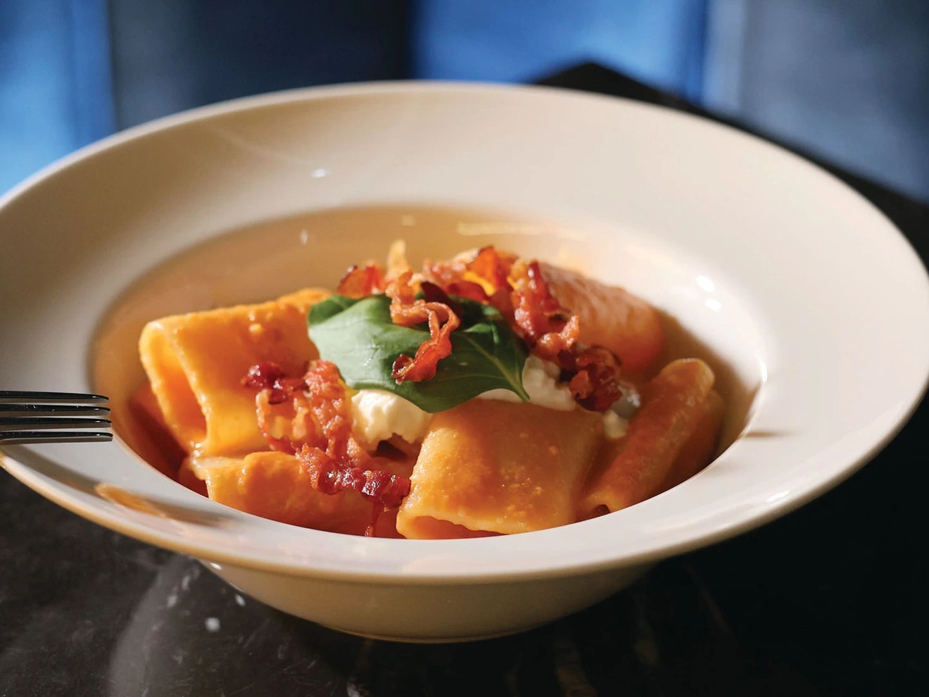 The paccheri ai tre pomodori features a delicate, flavorful tomato sauce topped with crispy bacon and creamy burrata PHOTO BY ARMANI THAO