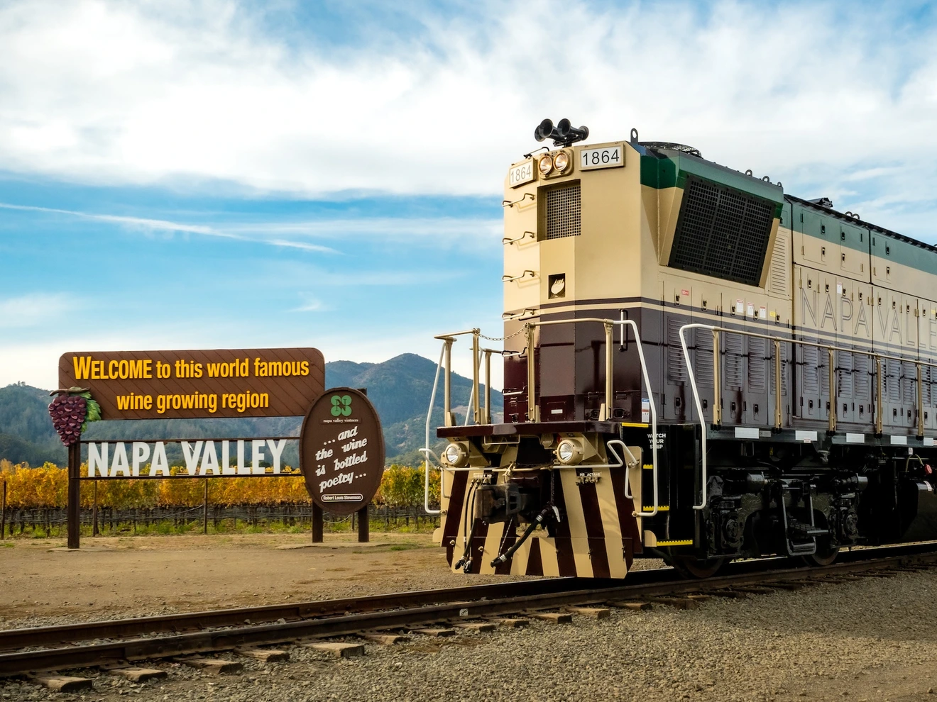 Train passing by a sign welcoming visitors to the world-famous wine-growing region, Napa Valley.
