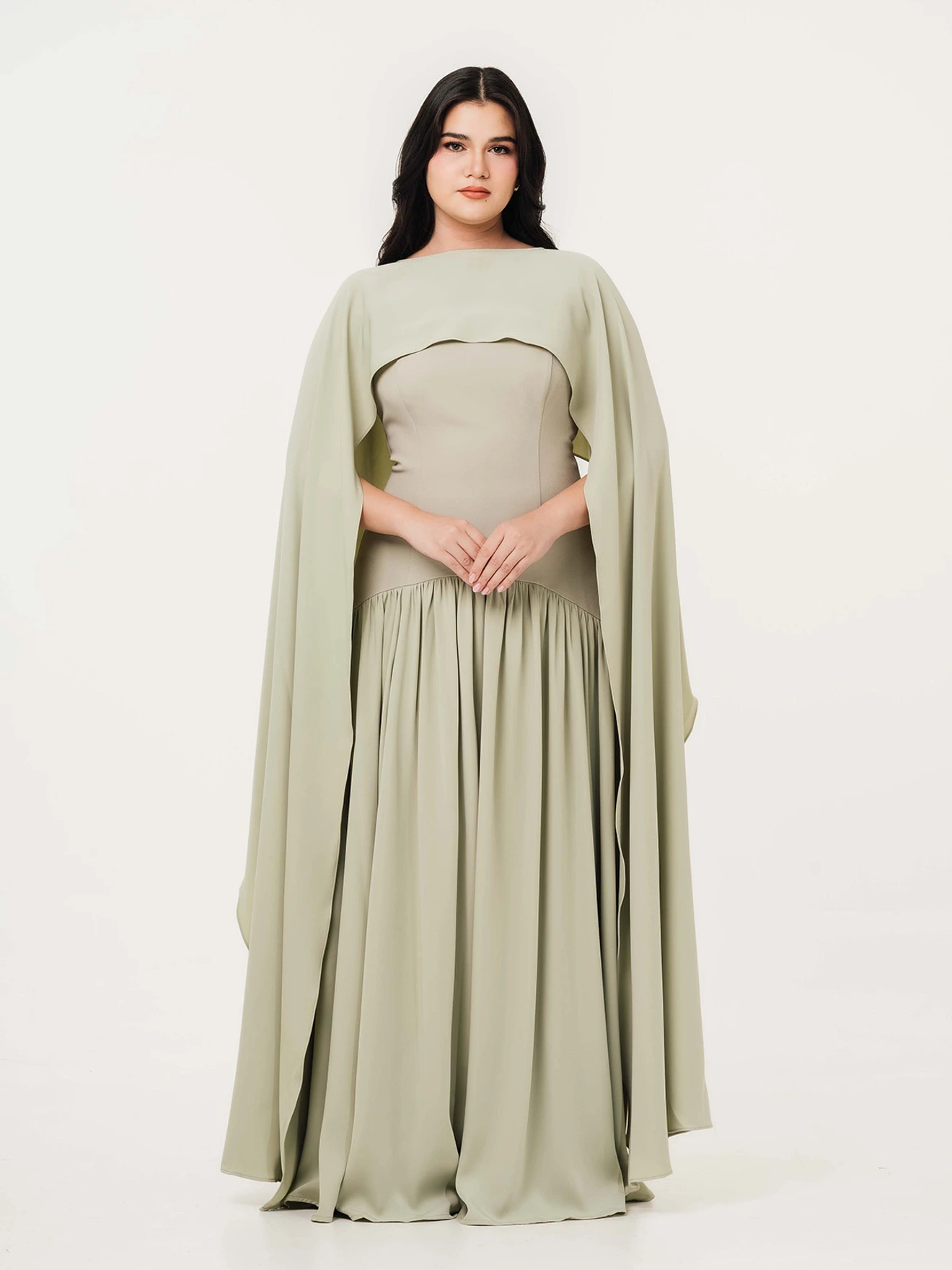 A woman is facing forward wearing a pale green dress.