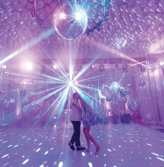 a kiss beneath the disco ball Photographed by Ben Finch