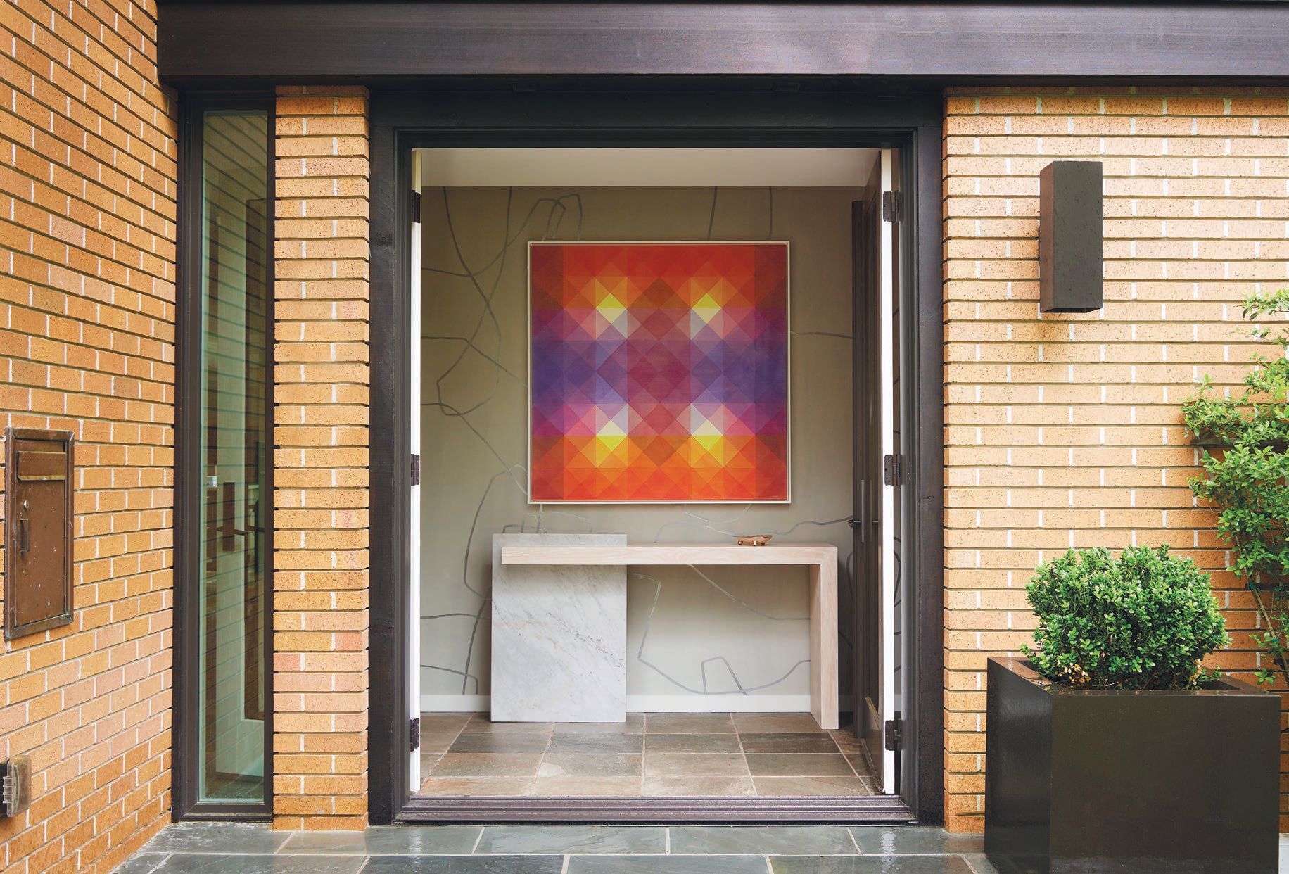 Entry features a Paul Marra console, Porter Teleo custom wallpaper and artwork from Field Kallop “Blossom” (2019 acrylic on canvas). PHOTOGRAPHY BY KRIS ELLIS; STYLING BY MICHELLE AVIÑA