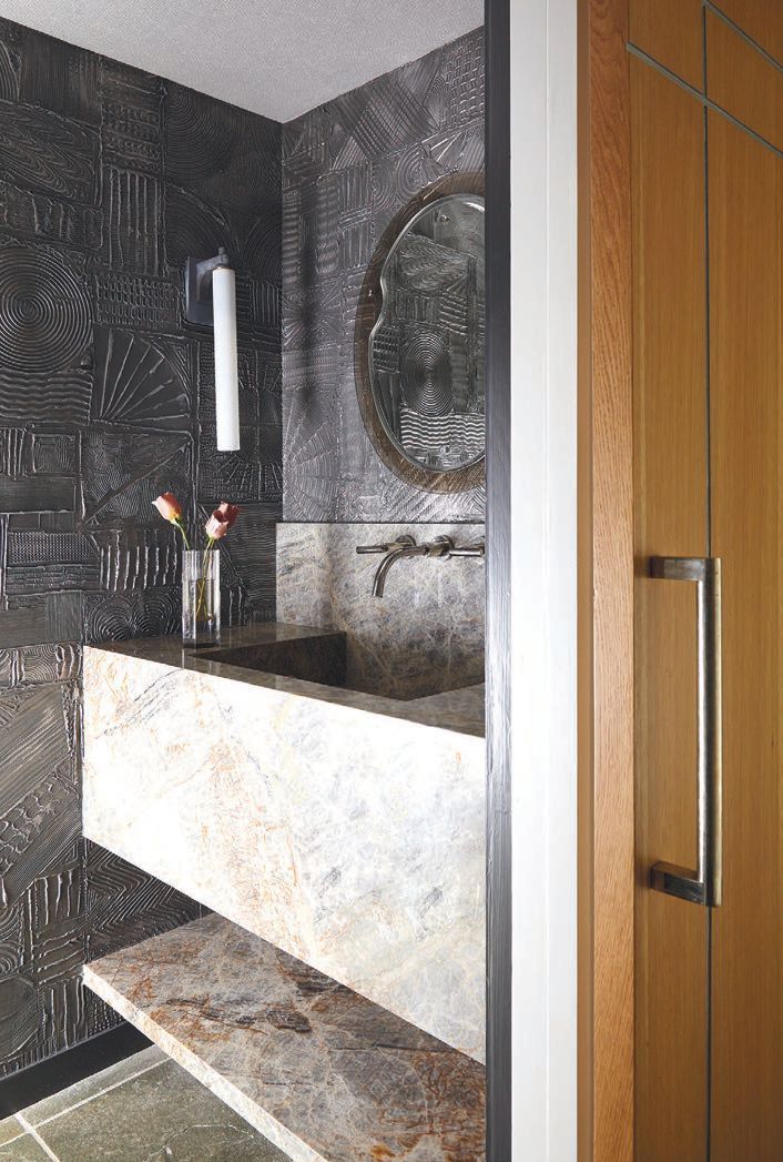 The powder bath features wallpaper from MJ Atelier and ceiling wallpaper from Phillip Jeffries as well as a chic sconce from Urban Electric. PHOTOGRAPHY BY KRIS ELLIS; STYLING BY MICHELLE AVIÑA