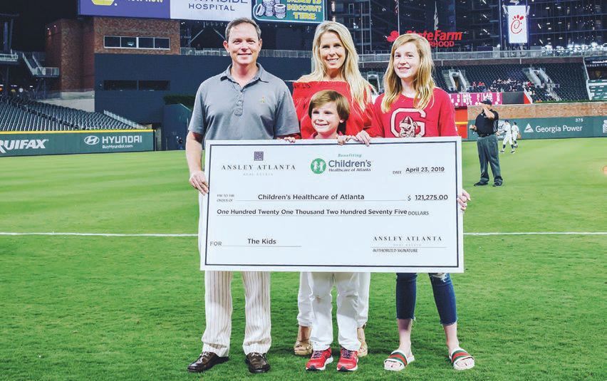 the Ansley family presenting $20,000 check to Children’s Healthcare of Atlanta at a 2019 Braves game PHOTO COURTESY OF ANSLEY REAL ESTATE CHRISTIE’S INTERNATIONAL