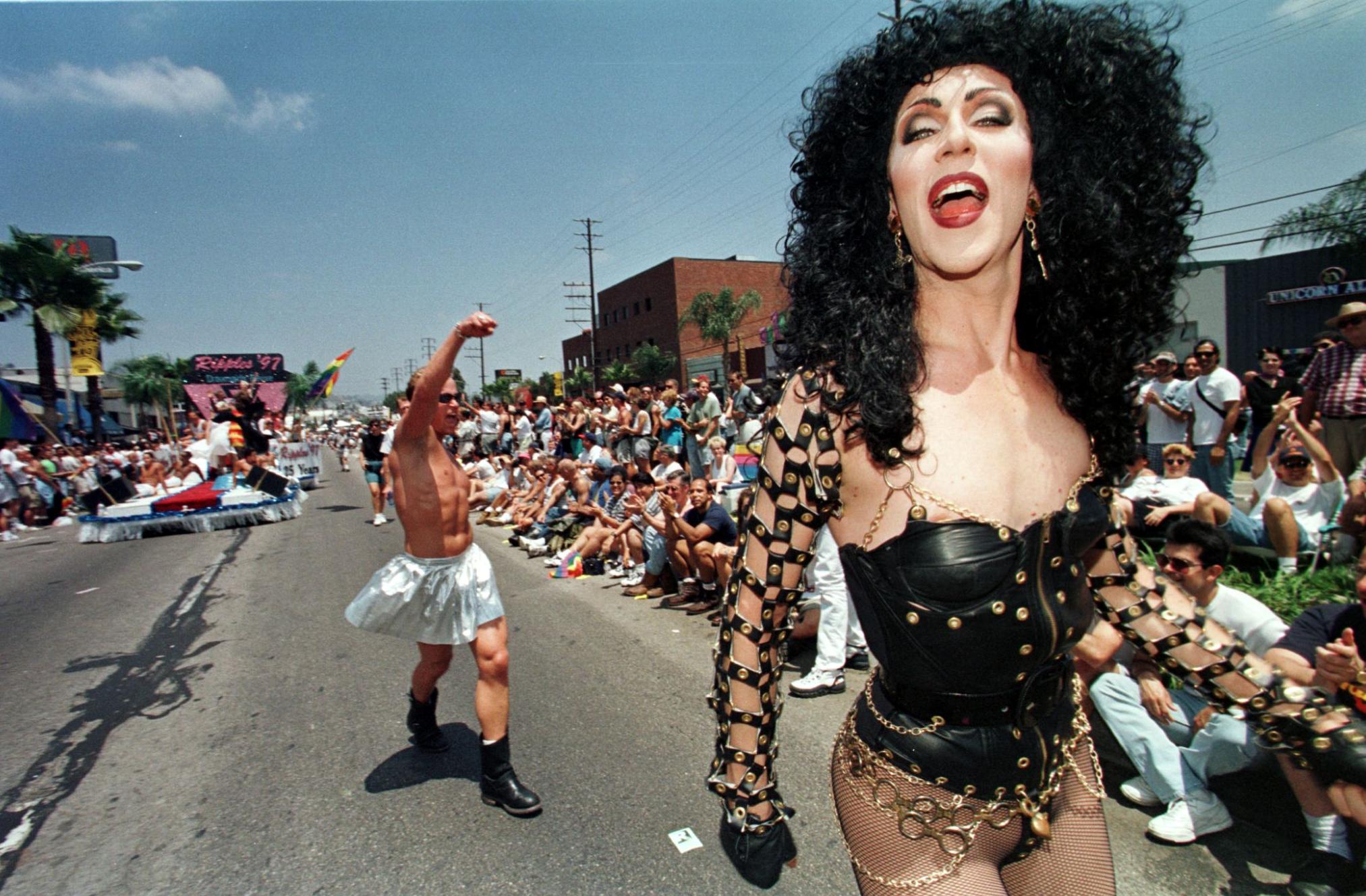 A man disguised as the actress Cher marches during