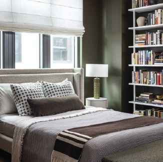 The design team created a tailored retreat for the primary suite, which boasts a bookshelves from CB2 photographed by JENN VERRIER