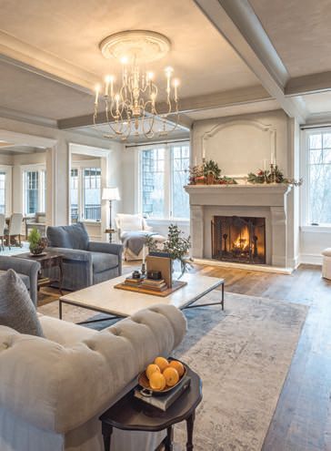 This project by B&D Builders features a grand fireplace and a coffered ceiling in the living room.
