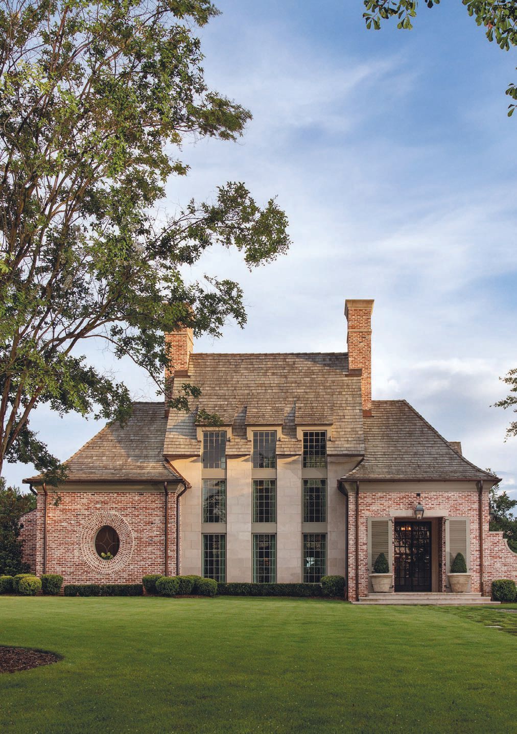 The great room features a custom limestone fireplace and soaring ceilings, creating a cozy yet grand aesthetic.