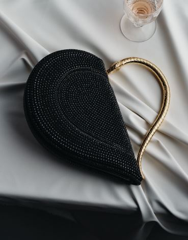 Bvlgari Serpenti Cuore 1968 top-handle bag with black Neige PavÃ© crystals applied on a suede base with black nappa internal lining, captivating snake body-shaped top handle in gold-plated brass embellished with engraved scales and zirconia eyes, and a pressbutton closure, bulgari.com. Photographed by JONG HYUP