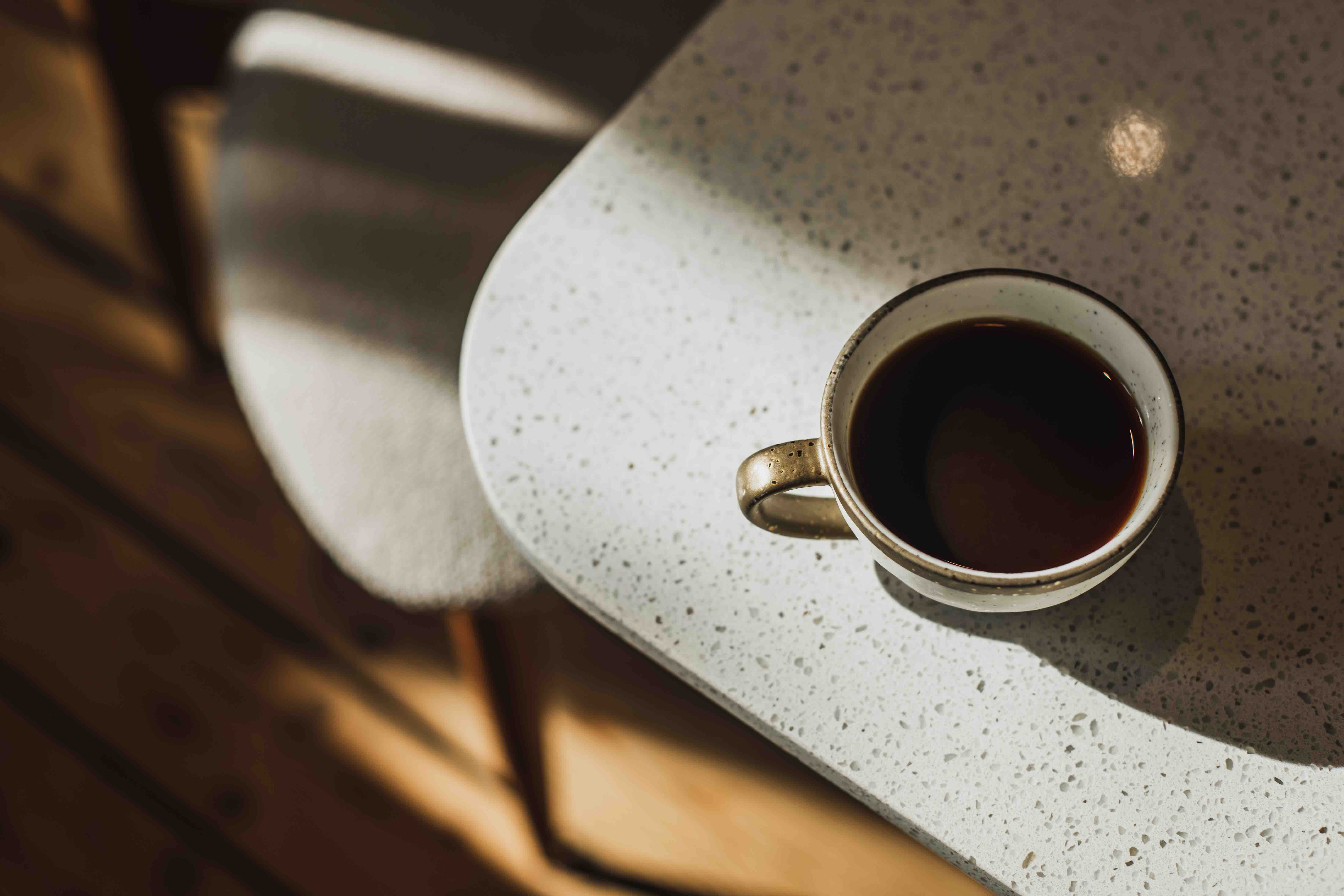 Cup of black filter coffee on table. Morning light in cafe.