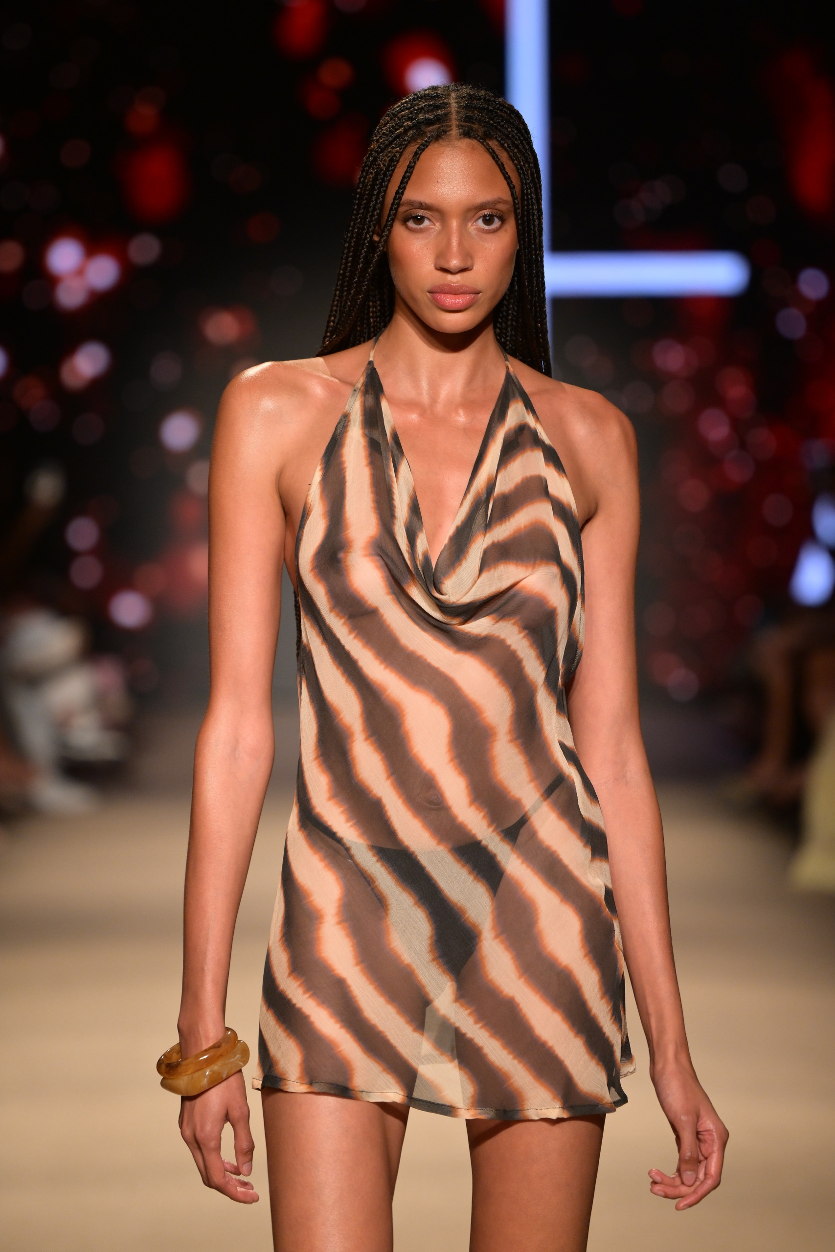 FAE's Resort 27; the coverup features an animal print as a model walks on the runway