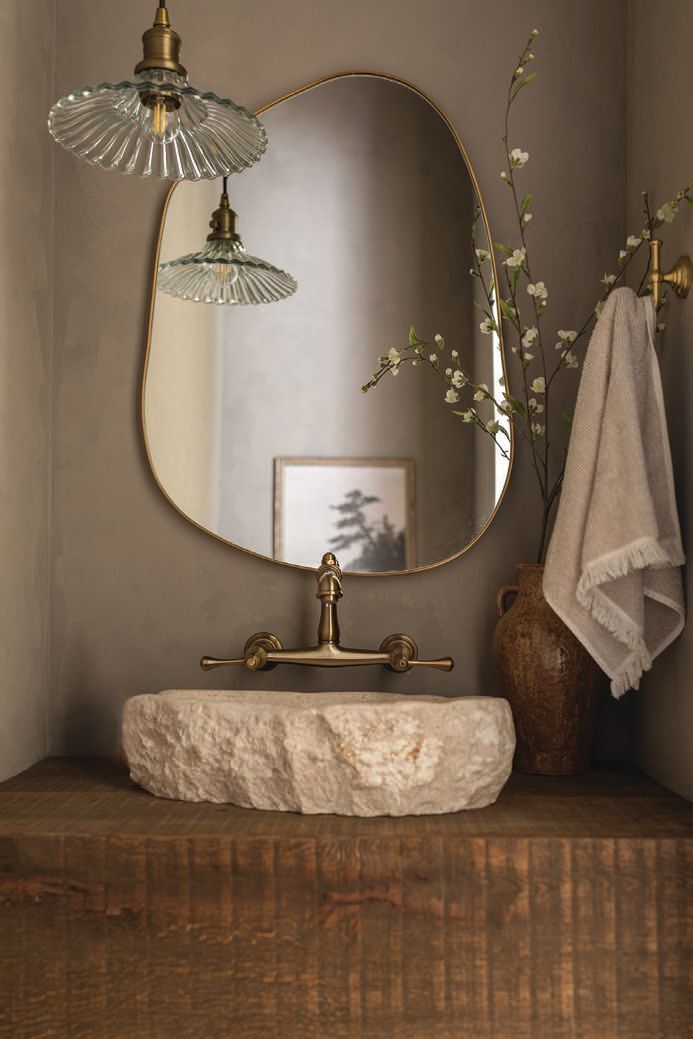 The powder room features a custom Ojinaga marble sink with a Mid-Century modern pendant light. photography by MARY CRAVEN DAWKINS stying by LEAH SELVIG ROBINSON