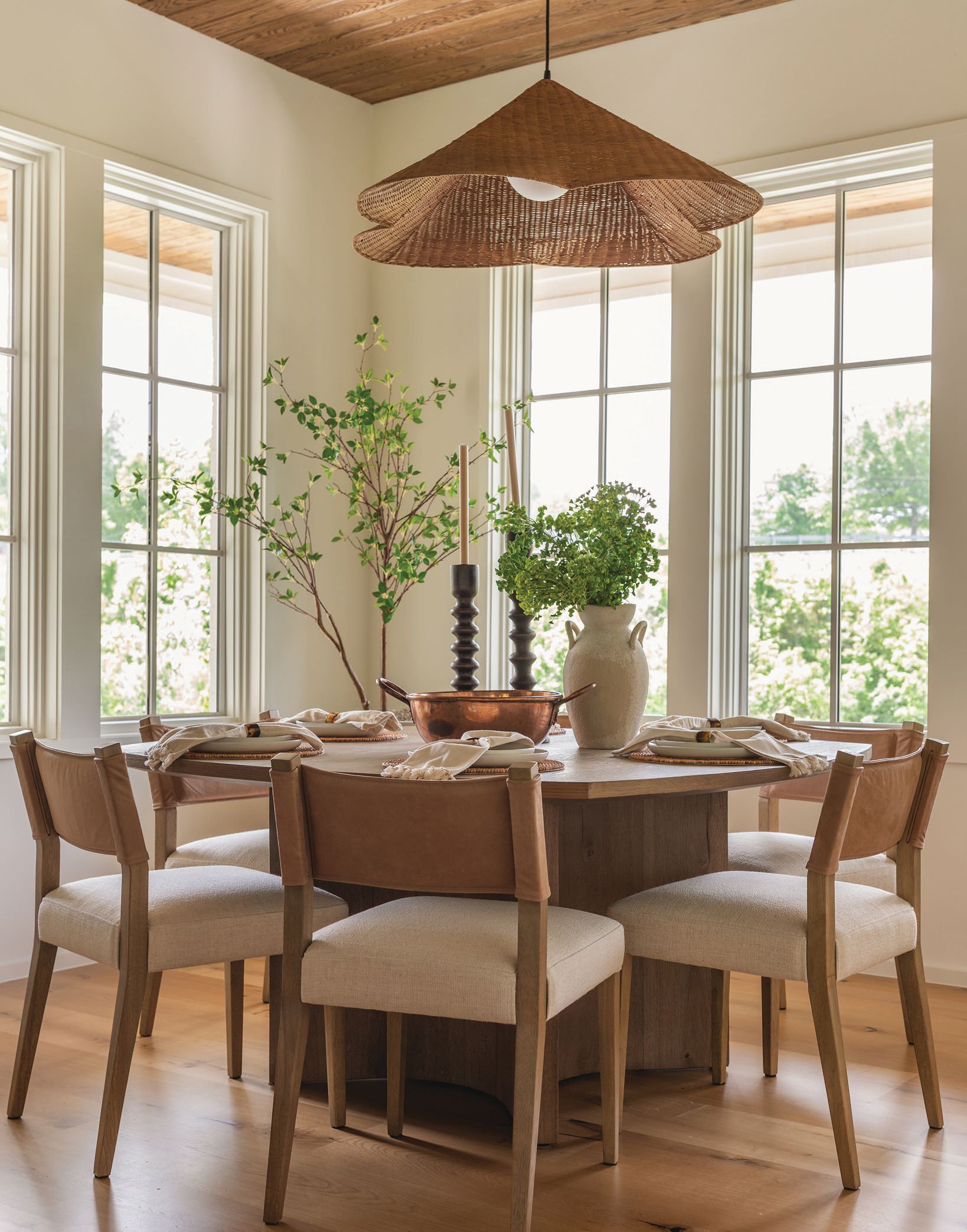 The breakfast nook is a family hub where Abby opted for freestanding furniture versus a built-in banquette for flexibility and flow. The rattan pendant fixture is Lulu & Georgia and the table and chairs are from Invision Design. photography by MARY CRAVEN DAWKINS stying by LEAH SELVIG ROBINSON
