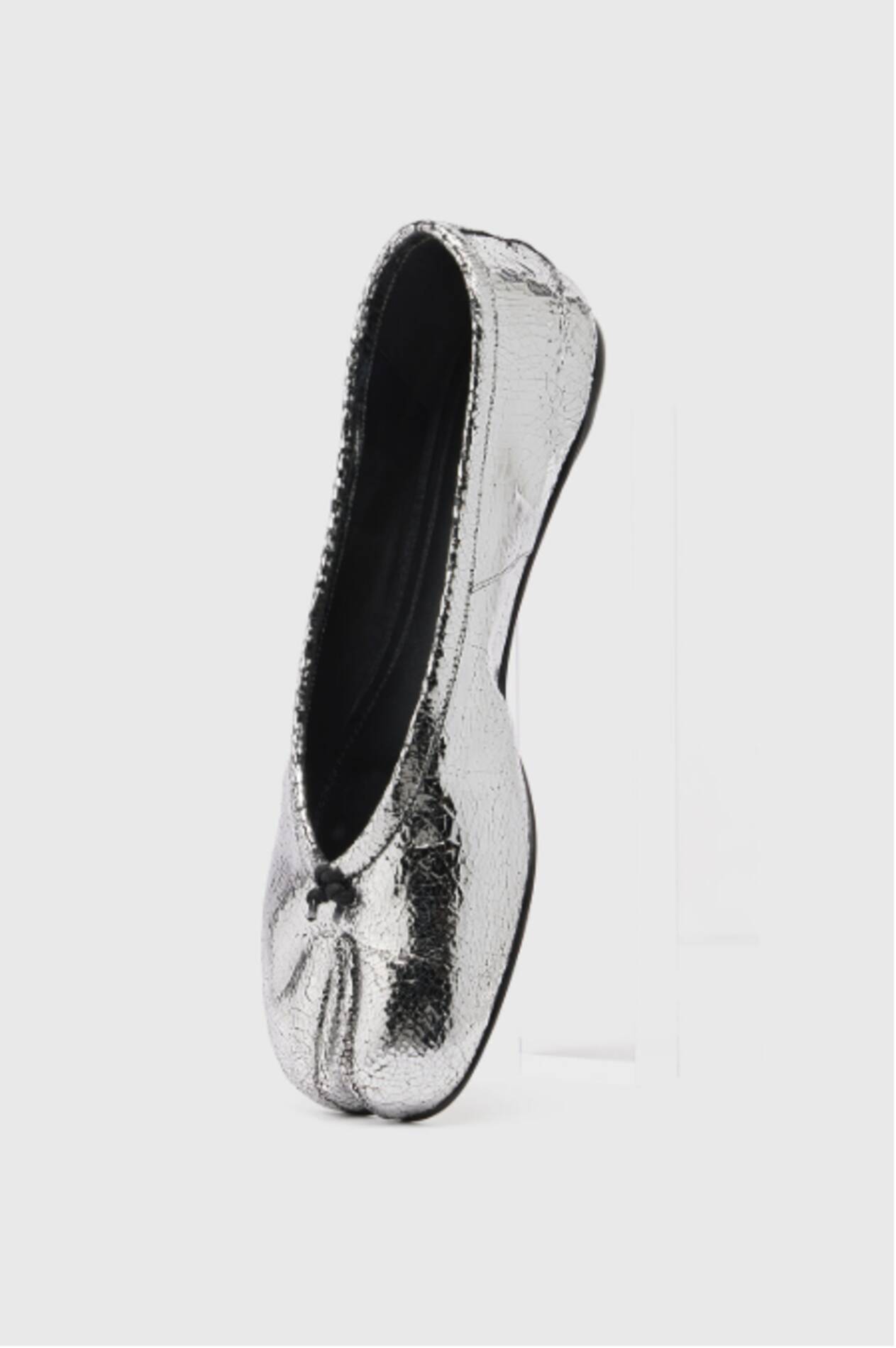 Silver metallic ballet flat shoe with gathered toe and black interior lining on white background.