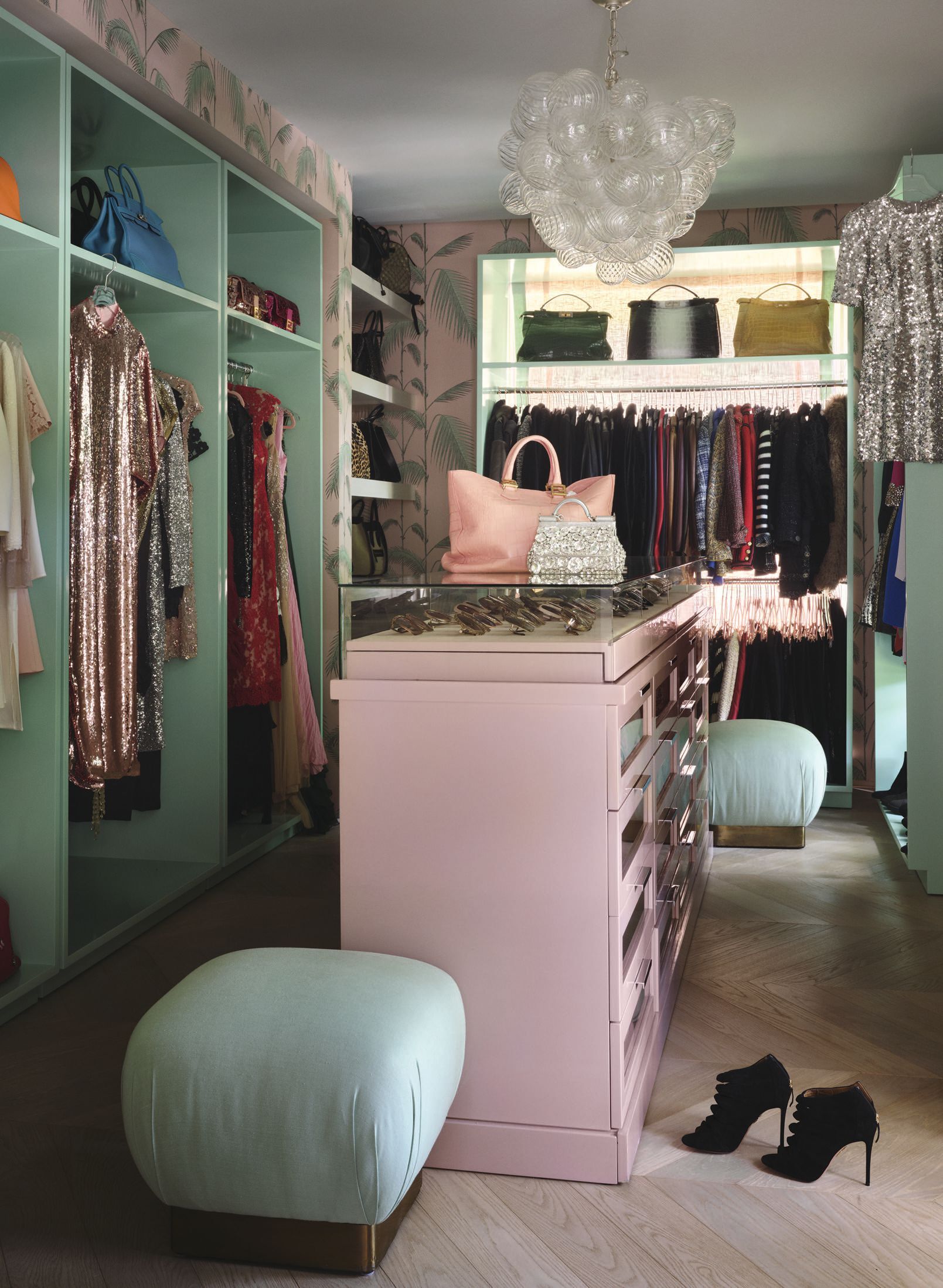In the dressing room, Cole & Sonâs Palm Leaves wallpaper in pink and mint sets a playful tone, complemented by an island painted in Benjamin Mooreâs Fruit Shake 2088- 60 and outer cabinetry in Minty Green 2042-70. PHOTO BY HOPE ROLLINS