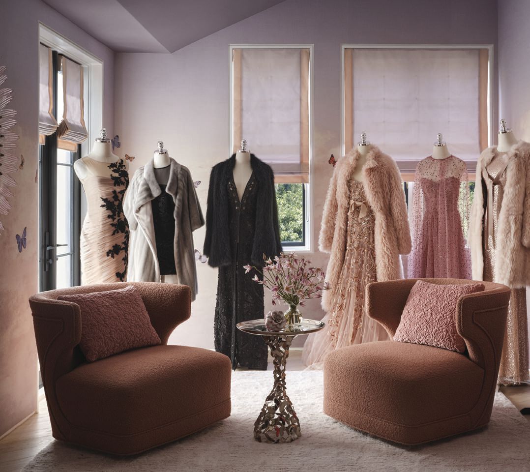 In the couture closet, Phillip Jeffriesâ Butterfly Sky wallcovering in Painted Lady sets the scene for Martyn Lawrence Bullard Atelier Marilyn chairs, a John Lyle Design butterfly side table and a Soho Home mirror. Jim Thompson Seda fabric trims the Roman shade, with Romo Vintage Rose pillows and a Marc Phillips rug completing the space. PHOTO BY HOPE ROLLINS